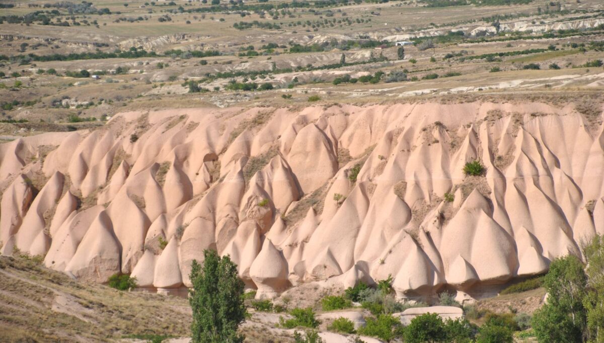 Traveler arriving in Cappadocia with view of cave houses and rock formations near sunset