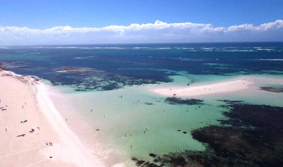 Traveler arriving on the Kenyan coast near Mombasa with palm-fringed beach and turquoise sea