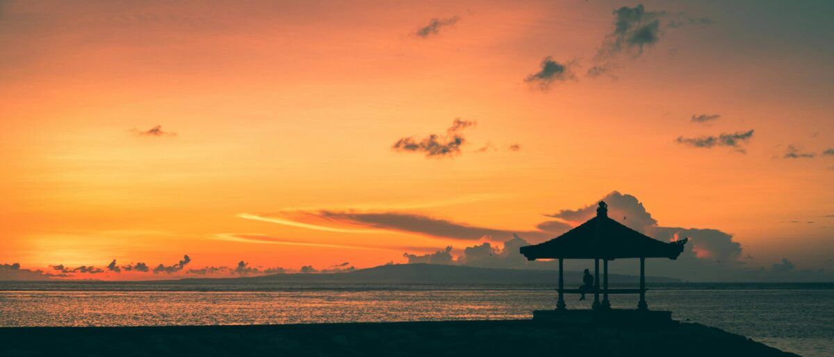 Traveler at Bali’s Denpasar airport looking out at planes on the tarmac before departure