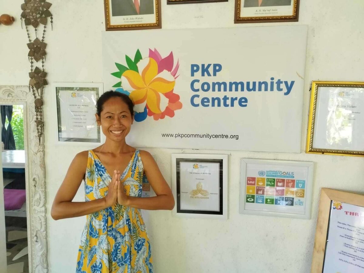 Traveler joining a community project in rural Bali, sharing stories with local women at the PKP Community Centre