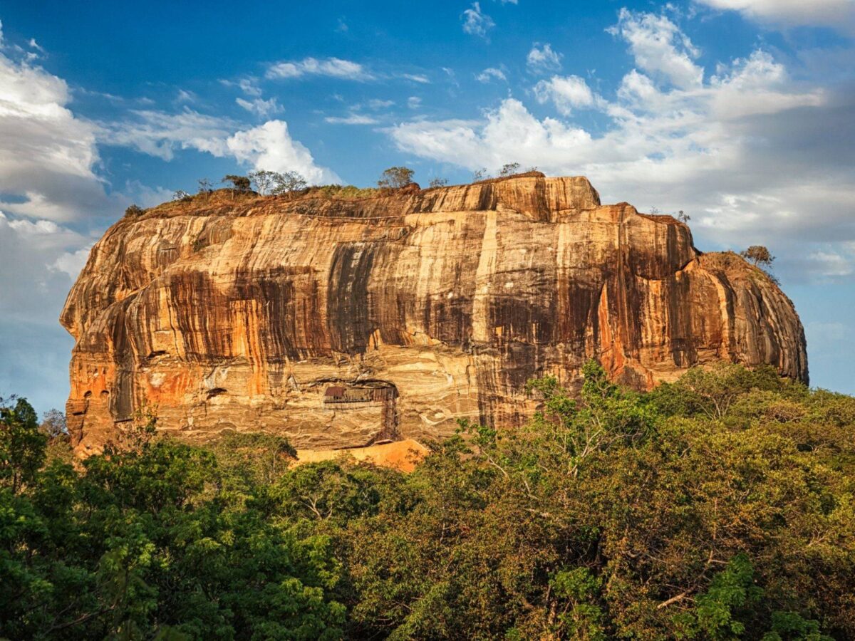 View from the top of Sigiriya rock fortress over gardens and green forest stretching to the horizon
