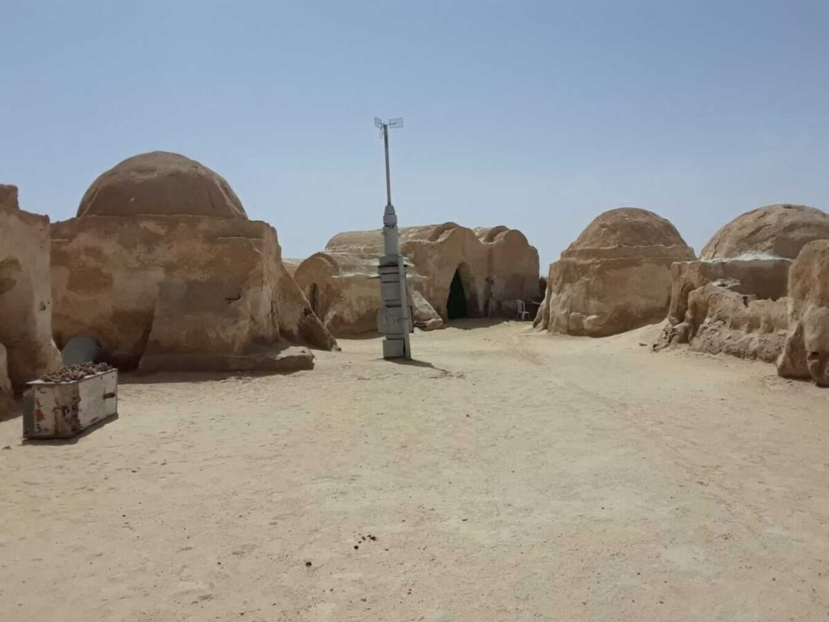 View of a seaside hotel in Djerba, Tunisia, with pool, palm trees and families relaxing under the southern sun