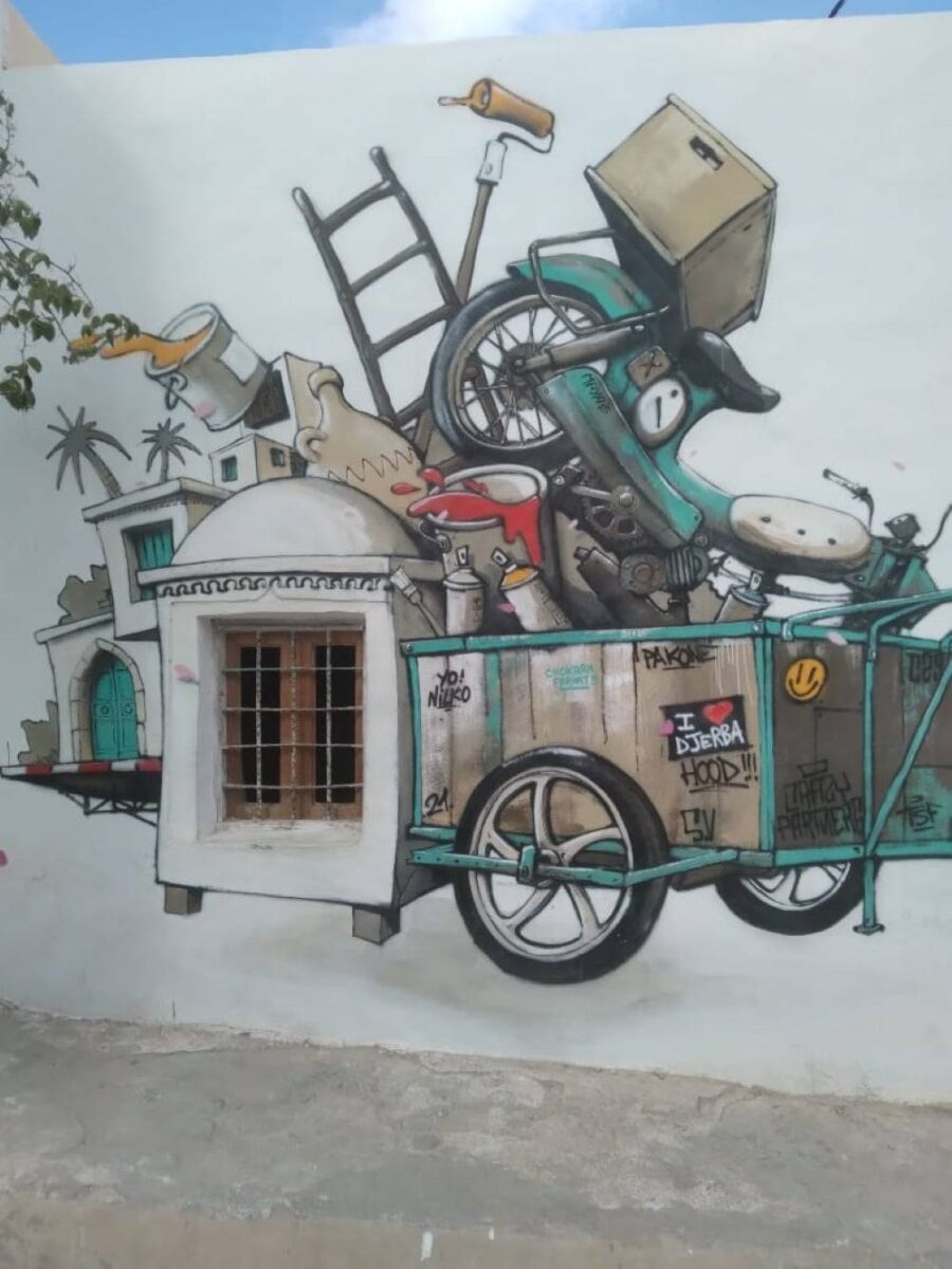 View of a traditional seaside hotel and sandy beach with palm trees on the island of Djerba, Tunisia
