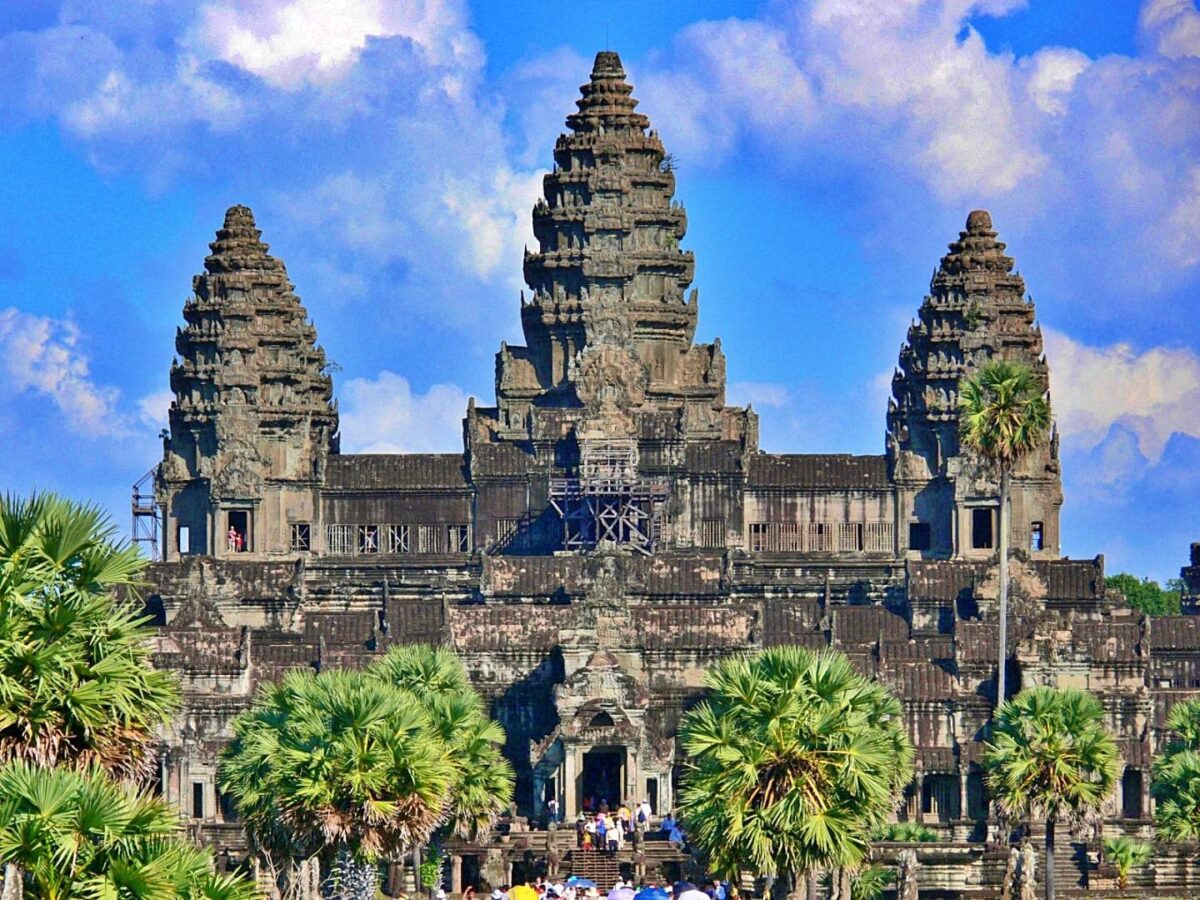 View of Angkor Wat temple with lotus pond in front under a blue sky in Cambodia