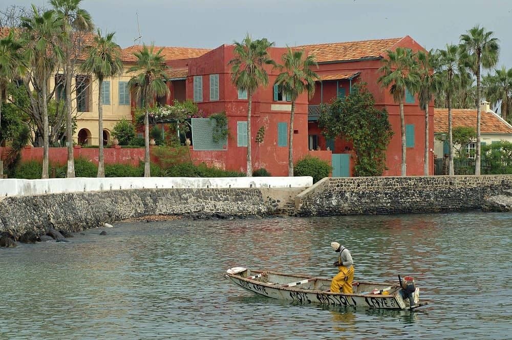 View of Gorée Island’s colorful colonial houses and boats moored in the bay near Dakar, Senegal