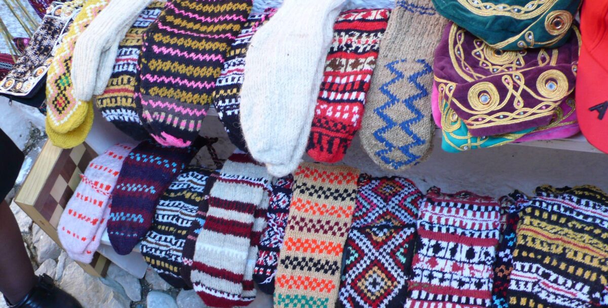 View of Kruja’s hillside old town with red-roofed houses, fortress walls and surrounding green mountains in Albania