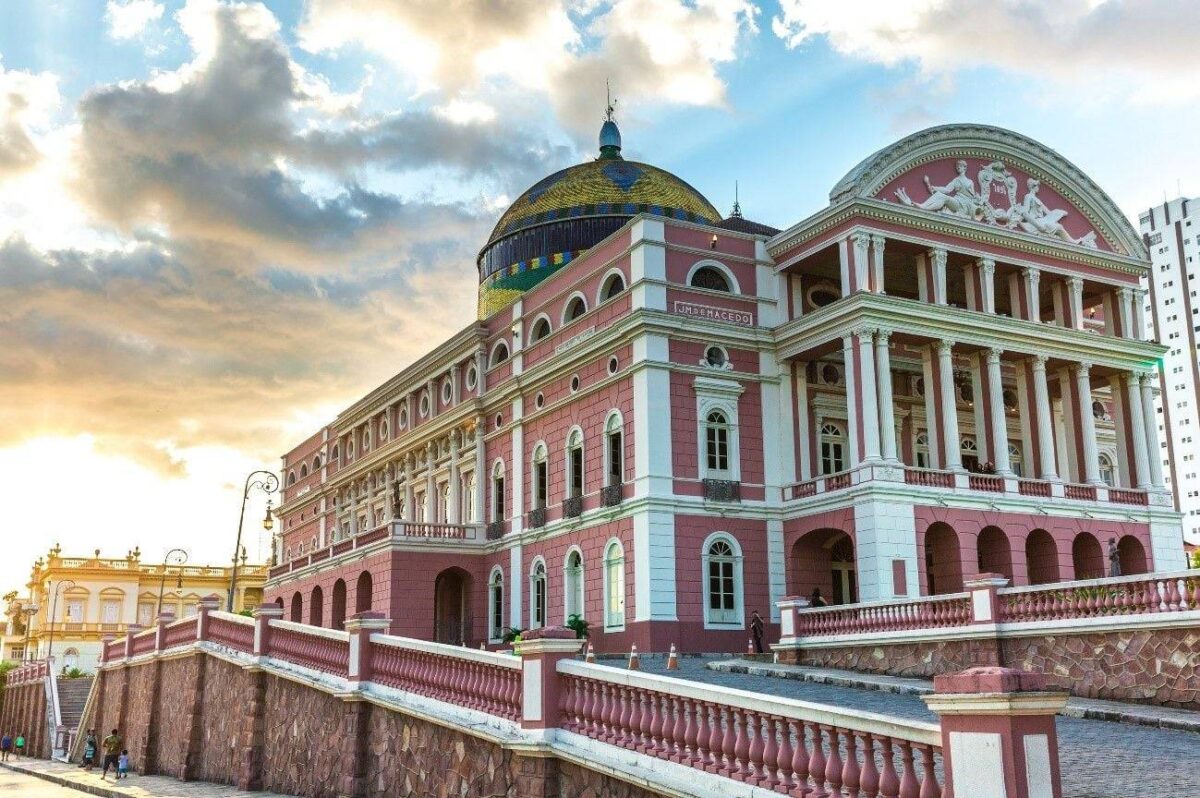 View of Manaus city centre with the colourful dome of the Amazon Theatre rising above historic buildings under a tropical sky