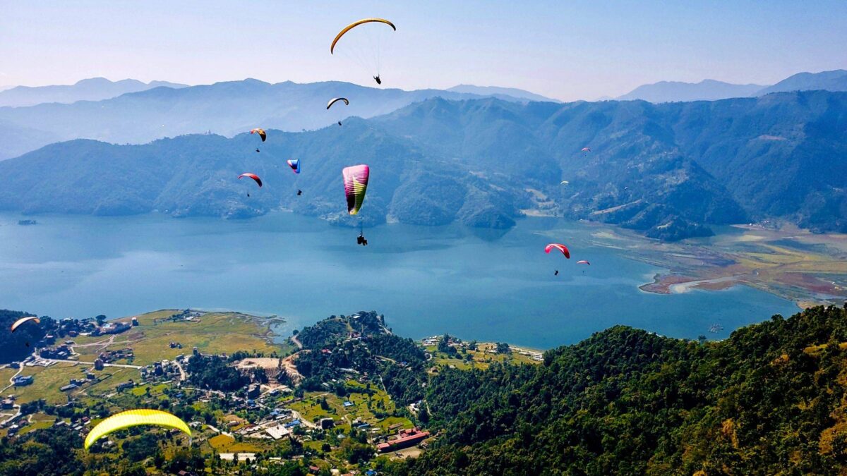 View of Phewa Lake in Pokhara with colorful boats and Annapurna mountains in the background