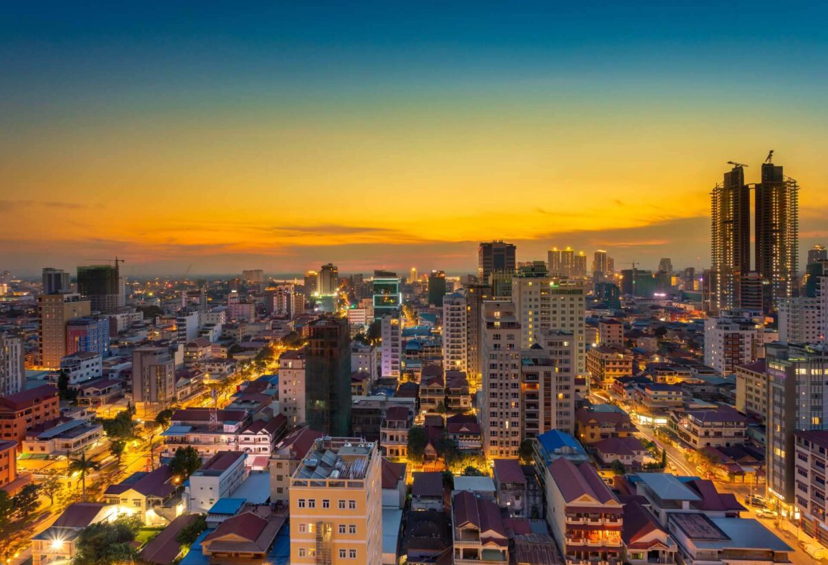 View of Phnom Penh skyline and riverside with boats on the Tonle Sap River at sunset
