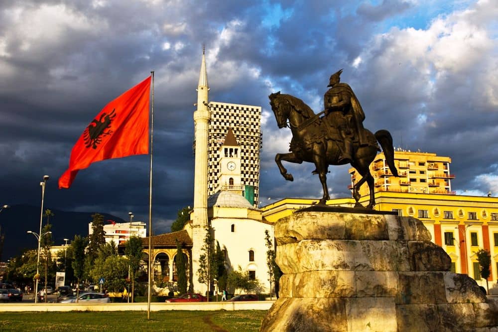View of Tirana, Albania, with colorful buildings and mountains in the background under a clear sky