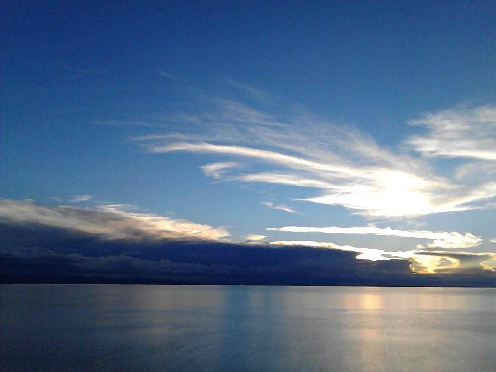 View over Copacabana on Lake Titicaca with white church towers, colorful houses and deep blue water beneath a clear sky