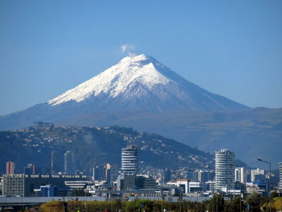 View over Quito with colonial and modern buildings surrounded by green Andean mountains