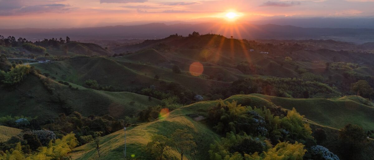 View over rolling coffee-covered hills from a viewpoint near Filandia with colorful town below