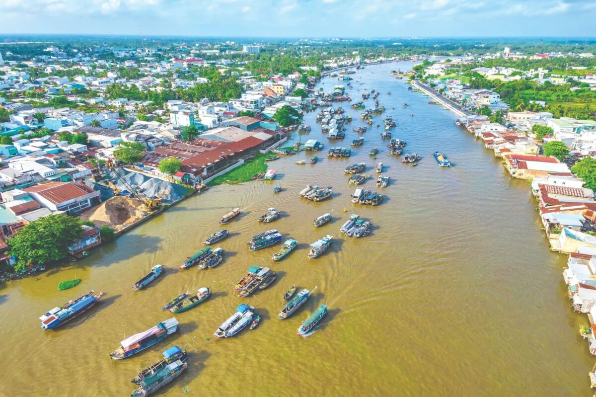 Wooden bungalows of Mekong Lodge surrounded by tropical gardens along a river in Vietnam’s Mekong Delta